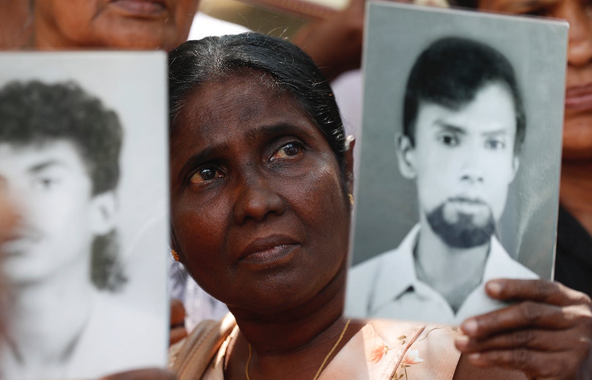 A woman holds a picture of a missing relative at a protest calling for investigations into enforced disappearances, Colombo, Sri Lanka, February 14, 2020.