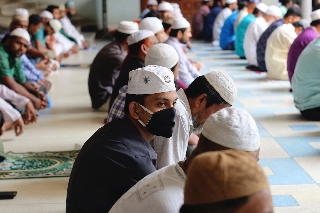 Muslims wear protective masks while offering Friday prayers