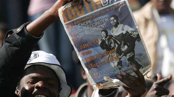 FILE: A South African youth holds a placard during the commemoration of the 30th anniversary of the uprisings in Soweto, South Africa, Friday, June 16, 2006.