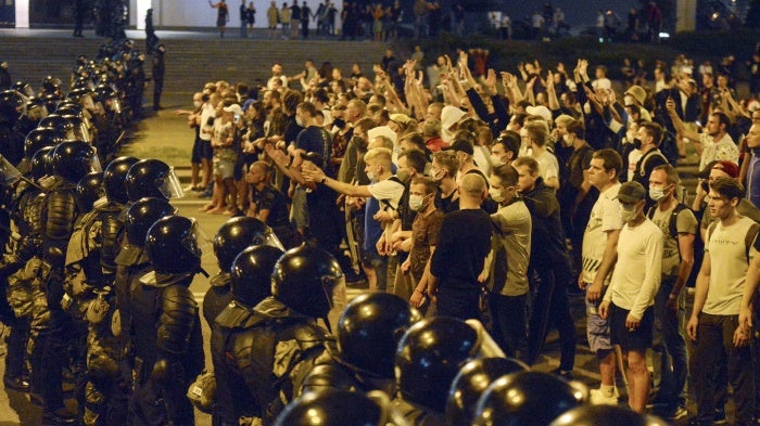 People argue with police during a rally after the Belarusian presidential election in Minsk, Belarus, late Sunday, Aug. 9, 2020.