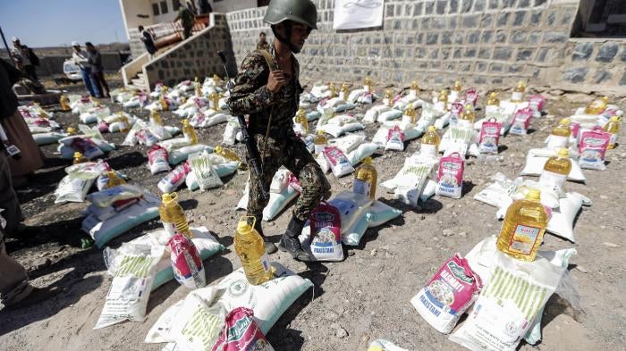 A uniformed soldier walks through aid packages