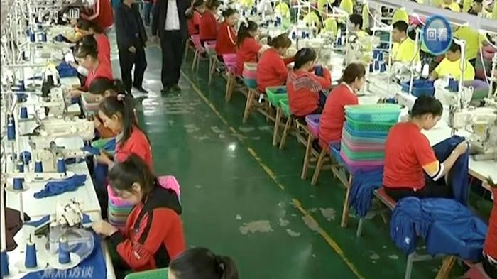 In this file image from undated video footage run by China's CCTV via AP Video, Muslim trainees work in a garment factory at the Hotan Vocational Education and Training Center in Hotan, Xinjiang, northwest China.