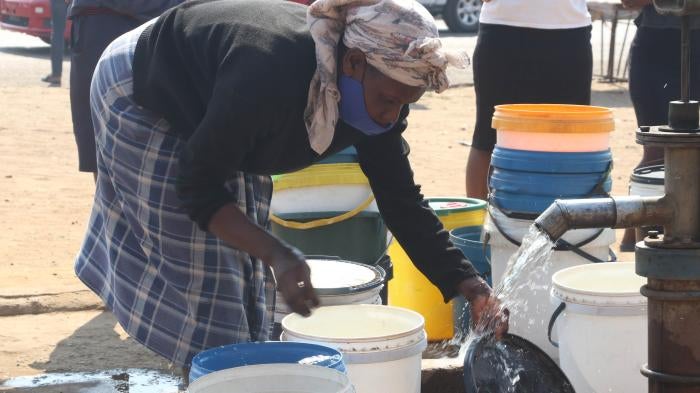 A woman collects water at a borehole in Mabvuku, Harare in Zimbabwe, August 28, 2021.