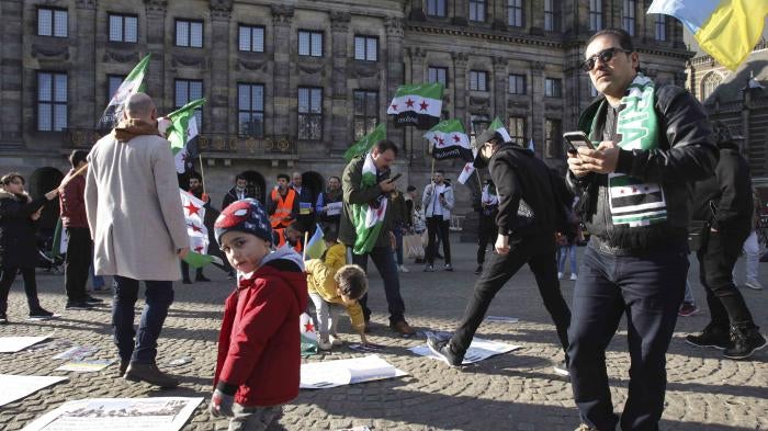 People display Syrian flags at a demonstration
