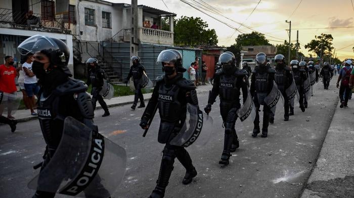 A line of policeman walking down a street
