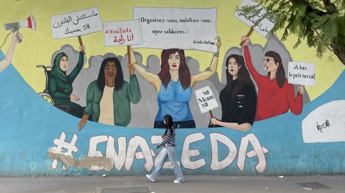 A woman walks by a street mural 
