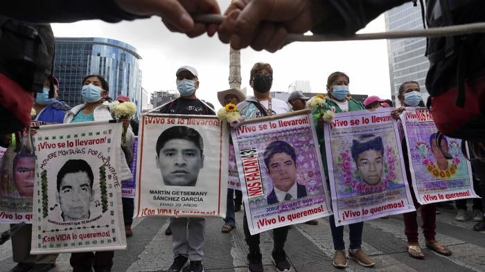 People march with placards showing faces of missing people