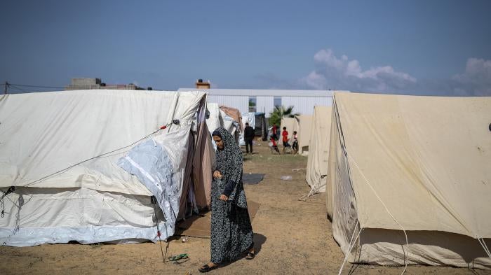 A girl walks around tents at a camp set up by the United Nations Relief and Works Agency for Palestine Refugees (UNRWA) for Palestinians who fled to the southern Gaza Strip, October 19, 2023. 