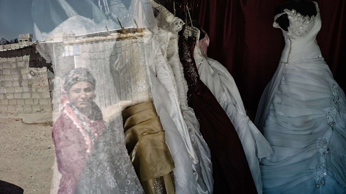 A woman looks at wedding dresses in a store window