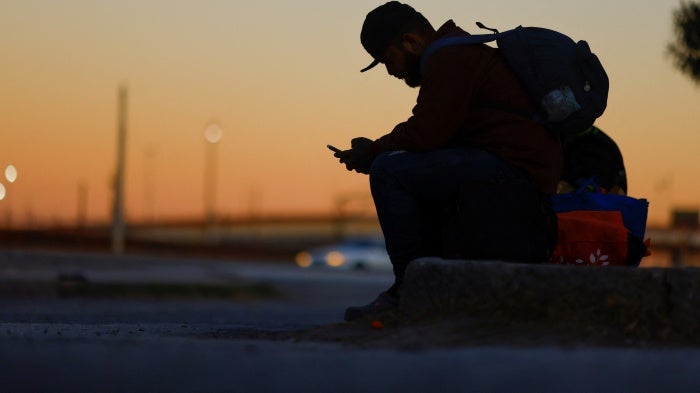 A seated man using a cell phone