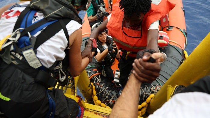 Médécins Sans Frontières rescue crew help a man on board following a rescue in the central Mediterranean Sea, September 20, 2024. 