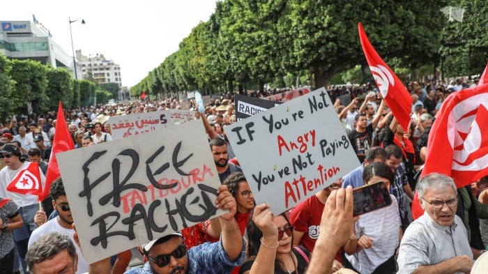 Demonstrators wave Tunisian flags and raise placards during a demonstration organized by the Tunisian Network for Rights and Freedoms in Tunis, Tunisia, on September 22, 2024.