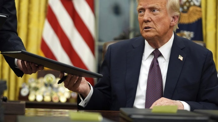 US President Donald Trump signs executive orders in the Oval Office of the White House, Washington, DC,  January 20, 2025.