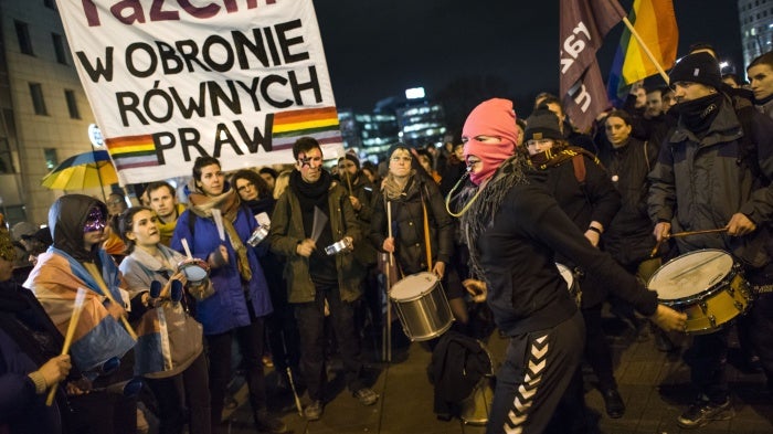 Activists raise a banner at a protest