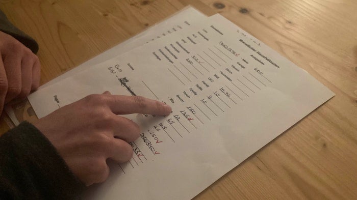 A single mother in low-wage work shows her monthly household budget to Human Rights Watch during an interview, Baden-Württemberg, February 2023.