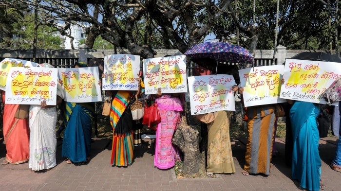 People hold placards at a protest