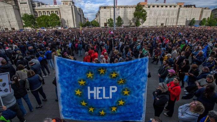 A protester holds up an EU flag with "help" written on it, during a demonstration in Budapest on May 18, 2025 against a bill empowering the government to sanction civil society organizations and media it deems threats to the country's sovereignty.