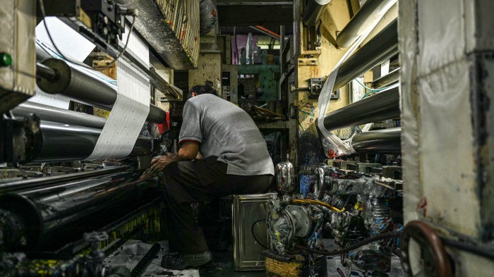 A worker inspects a machine processing color for plastic products at a factory in Malaysia, October 9, 2024.