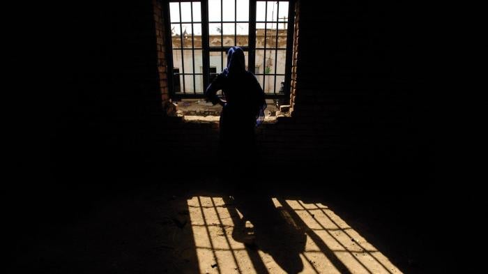 A woman prisoner looks out a window in Parwan prison north of Kabul, Afghanistan, in February 2011. The woman was convicted of moral crimes after a man from her neighborhood raped her. She later gave birth in prison.