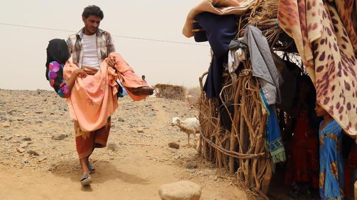 Fatima Ibrahim al-Marzuqi is being carried by her brother because she is not able to walk due to her injuries sustained during a cluster munition attack on Malus village on June 7. 