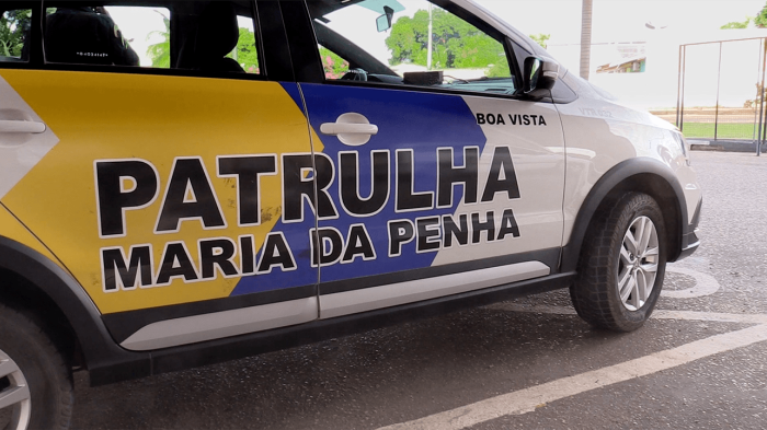 A close-up of a Brazilian police car with the words "Patrulha Maria da Pena" on its side.