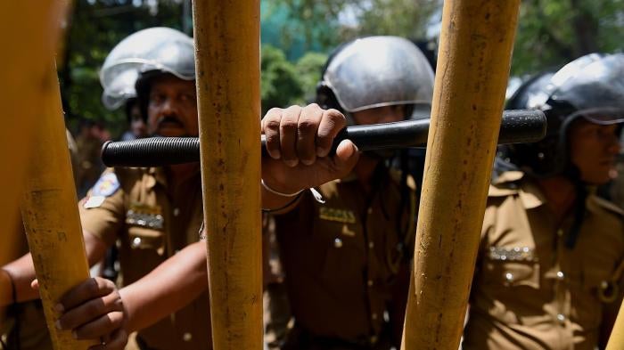 Sri Lankan police stand guard at a protest calling for the release of Tamil activists being held under the Prevention of Terrorism Act in Colombo, Sri Lanka, October 14, 2015.