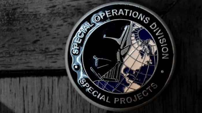 Medallion that includes the words ‘Special Operations Division’ with an image of Darth Vader over the globe on one side, and the words ‘Drug Enforcement Administration’ and the DEA logo on the other side. 