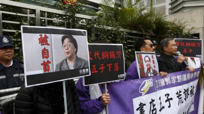 Members from the pro-democracy Civic Party carry a portrait of Gui Minhai (L) and Lee Bo during a protest outside the Chinese Liaison Office in Hong Kong, China January 19, 2016.