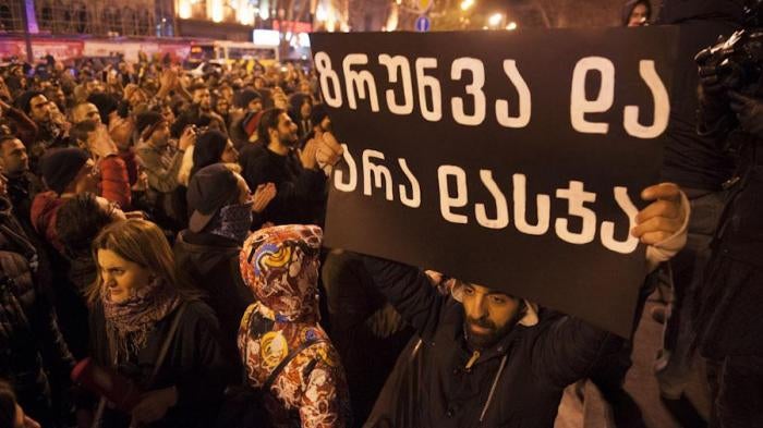 A sign which reads “Care instead of Punishment” is held aloft at a protest rally calling for decriminalization of personal drug use, Tbilisi, Georgia, December 10, 2016. 
