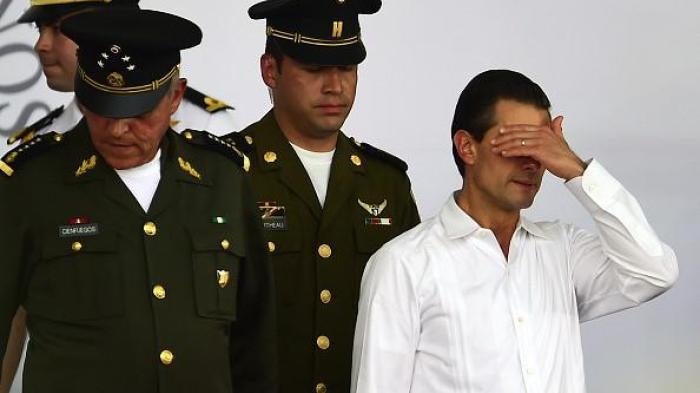Mexican President Enrique Pena Nieto (R) gestures during an event for the National Flag Day in Iguala, Guerrero State, Mexico on February 24, 2016. 
