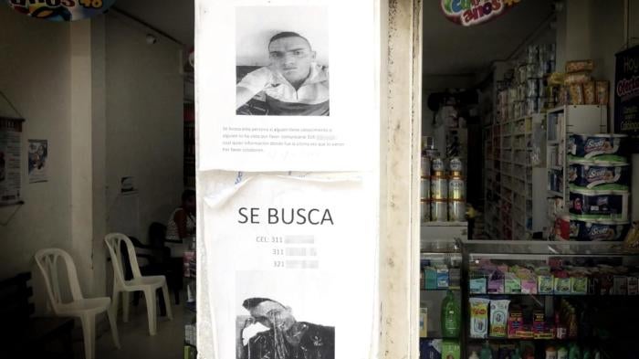 Posters requesting information on the whereabouts of two disappeared men on the wall of a store in the city of Tumaco, August 9, 2018. 