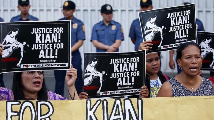 Protesters display placards and shout slogans during a rally outside the Philippine National Police headquarters to protest the killing by police of Kian Loyd Delos Santos, a 17-year-old grade 11 student