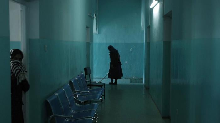 An employee cleans the corridor of the women's ward at the mental health hospital in Kabul, November 2012.