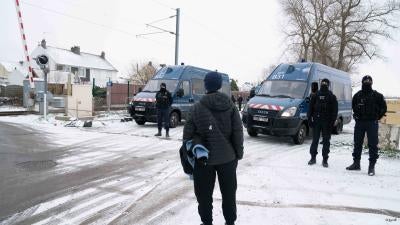 A teen stands in front of a group of policemen 