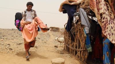 Fatima Ibrahim al-Marzuqi is being carried by her brother because she is not able to walk due to her injuries sustained during a cluster munition attack on Malus village on June 7. 