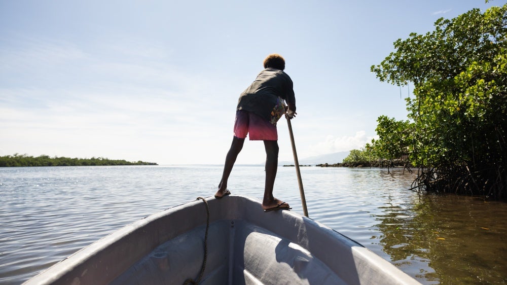 Boy on a boat in the mangroves near the village of Walande.