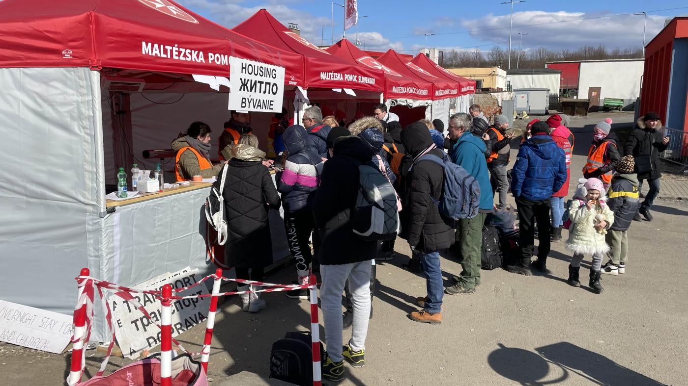 People lined up in front of red tents