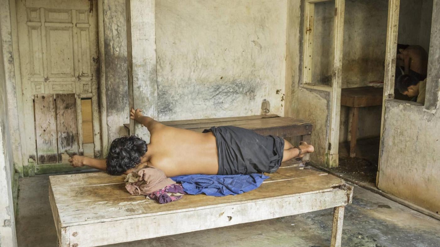 Seorang laki-laki yang diduga atau didiagnosis memiliki disabilitas psikososial terbaring dengan pergelangan kakinya dirantai ke dipan di panti