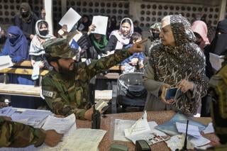 A man in military uniform points in the face of a woman 