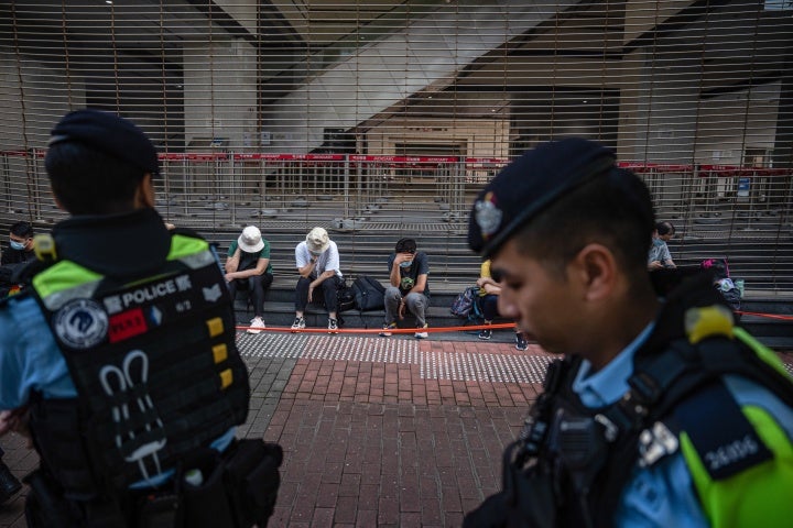 People wait to enter the court to hear mitigation pleas for pro-democracy activists convicted under the Beijing-imposed security law in Hong Kong, July 5, 2024.