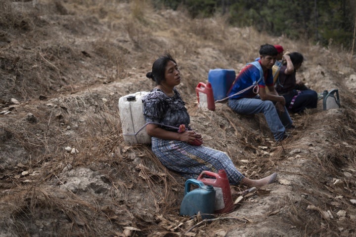 A family stops to rest while transporting water from a well in Santa María Chiquimula municipality, Totonicapán department. 