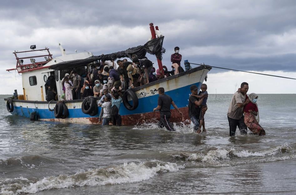 Local fishermen help Rohingya asylum seekers as they arrive in North Aceh, Indonesia, June 25, 2020.