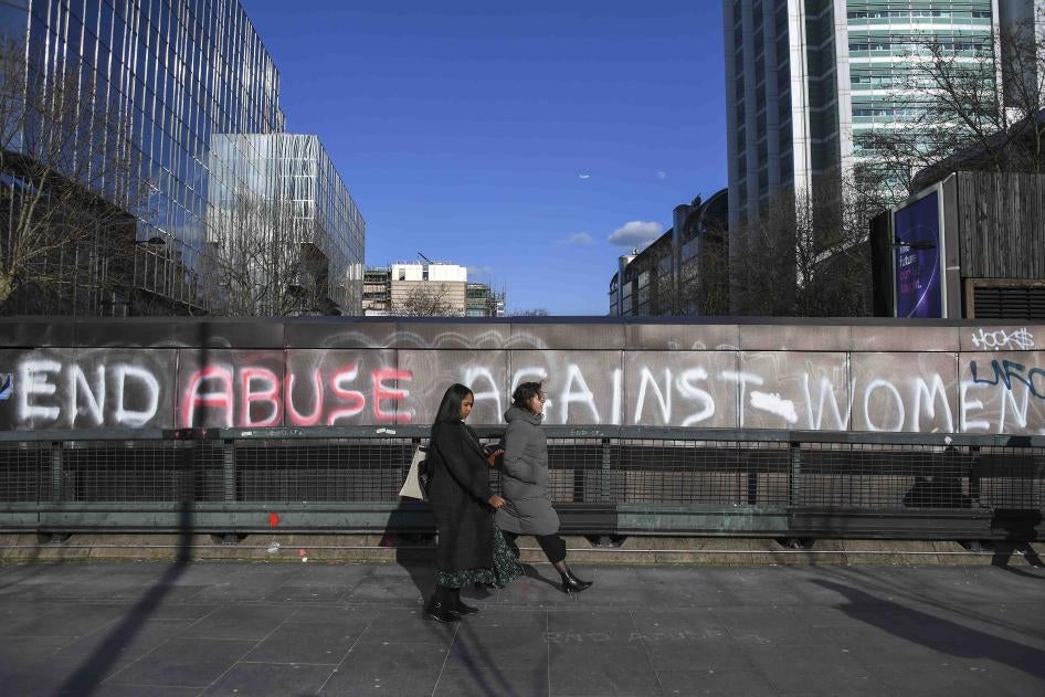 People walk past a graffiti reading ‘End abuse against women’ on Euston Road, in London, Friday March 6, 2020.