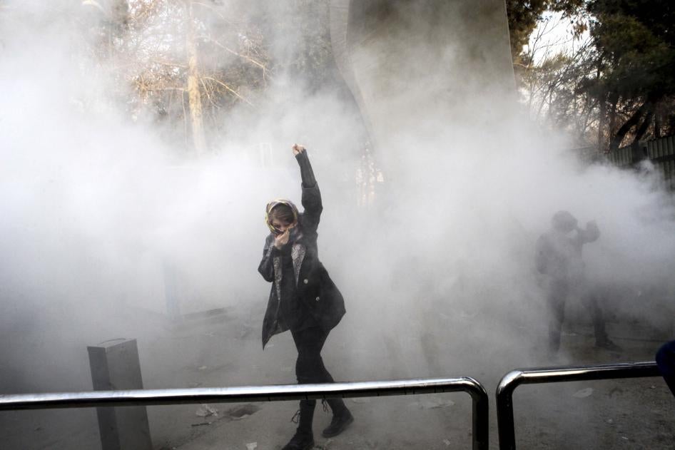 On December 30, 2017, a university student attends a protest inside Tehran University while a smoke grenade is thrown by anti-riot Iranian police, in Tehran, Iran.
