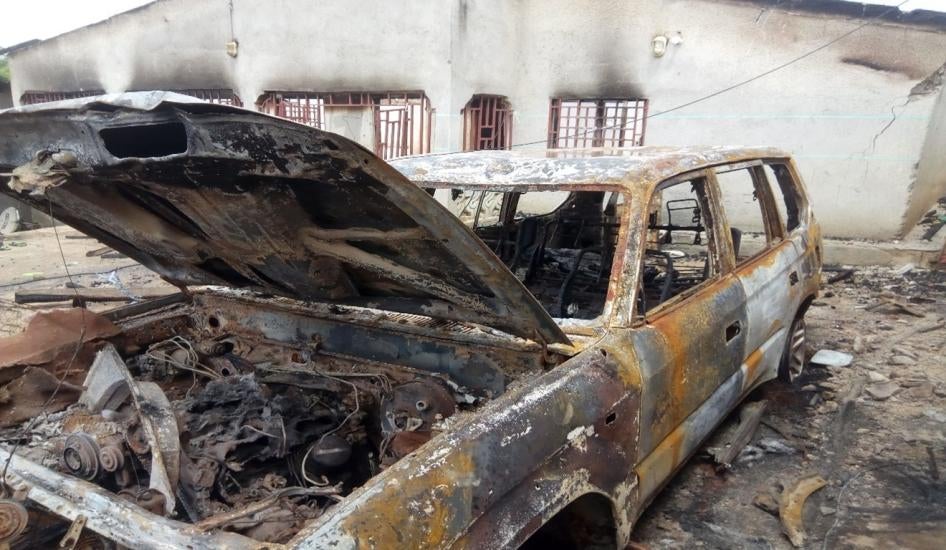 The burned remains of a car in front of a building