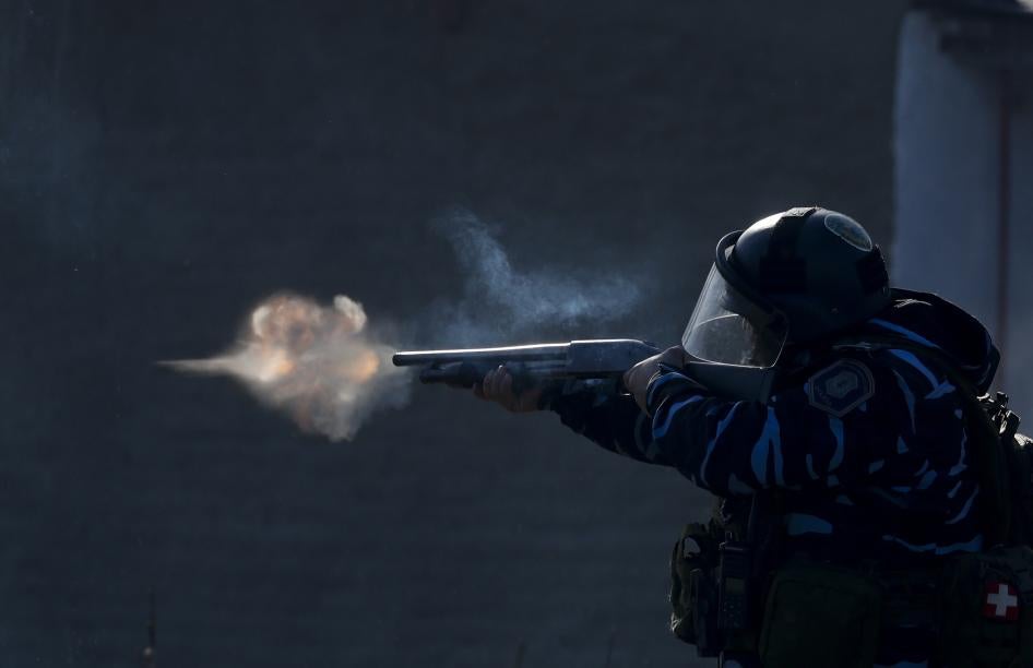 Un policía apunta su arma, mientras policías disparan gases lacrimógenos y balas de goma, durante enfrentamientos después de que la Policía desmantelara un campamento de ocupantes en Guernica, provincia de Buenos Aires, Argentina, el 29 de octubre de 2020.