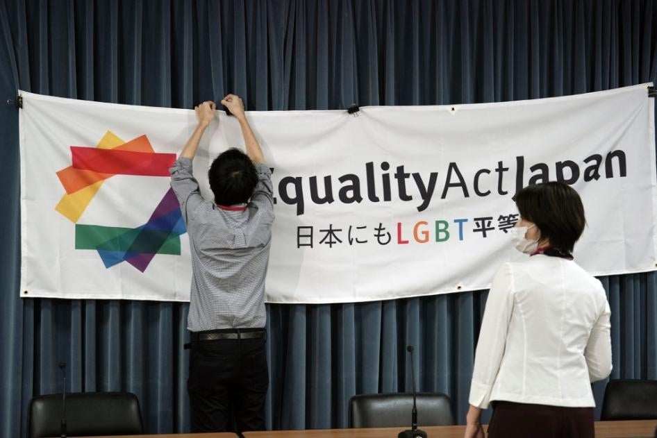 A staff member adjusts a banner for a press conference to launch international signature campaign for the enactment of the "LGBT Equality Law" as a legacy of the Tokyo Olympics Thursday on October 15, 2020, in Tokyo.
