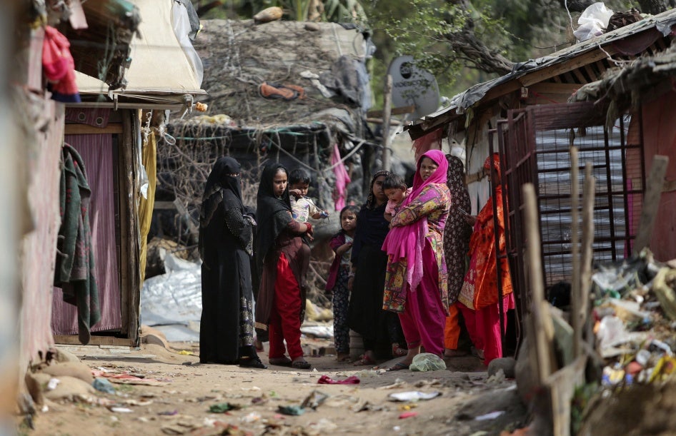 Rohingya refugees stand outside their makeshift camp on the outskirts of Jammu, India, March 7, 2021. 