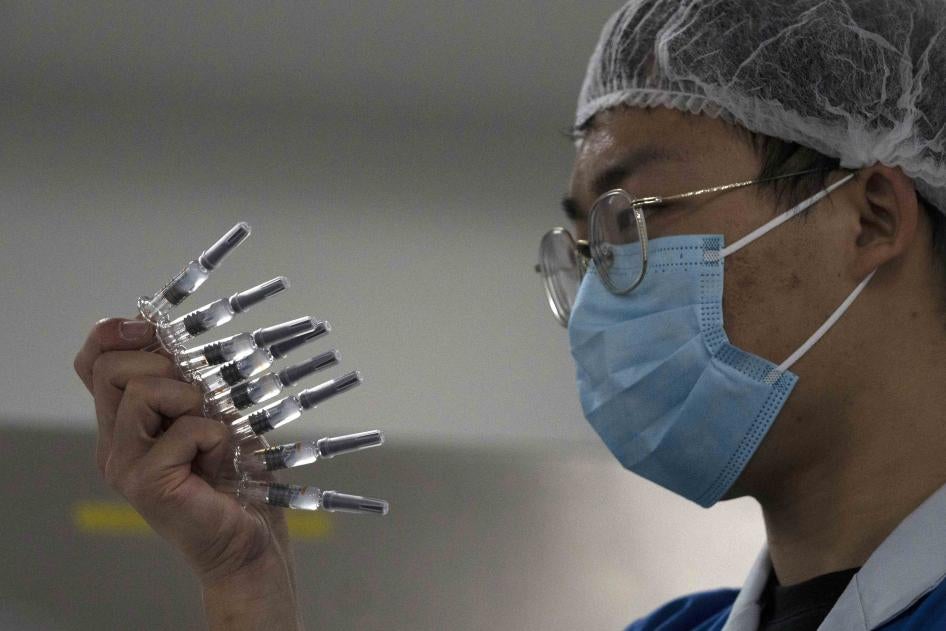 An employee manually inspects syringes of the SARS CoV-2 vaccine for Covid-19 in Beijing on September 24, 2020.
