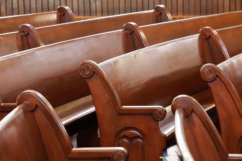 Curved pews are seen inside of a church. 